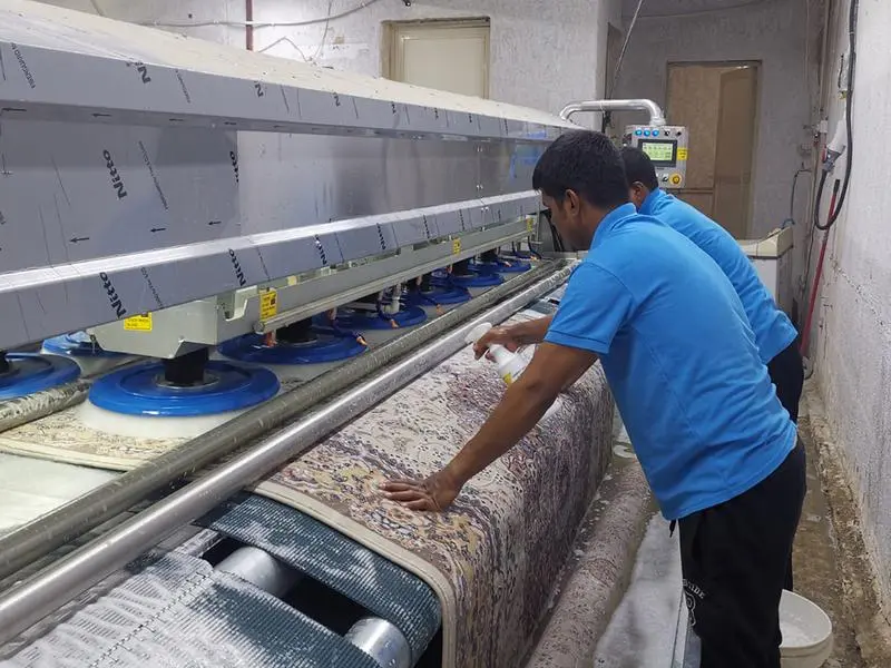 Two men wearing blue polo shirt, working on carpet washing machine - Cleaning Carpet by machine.