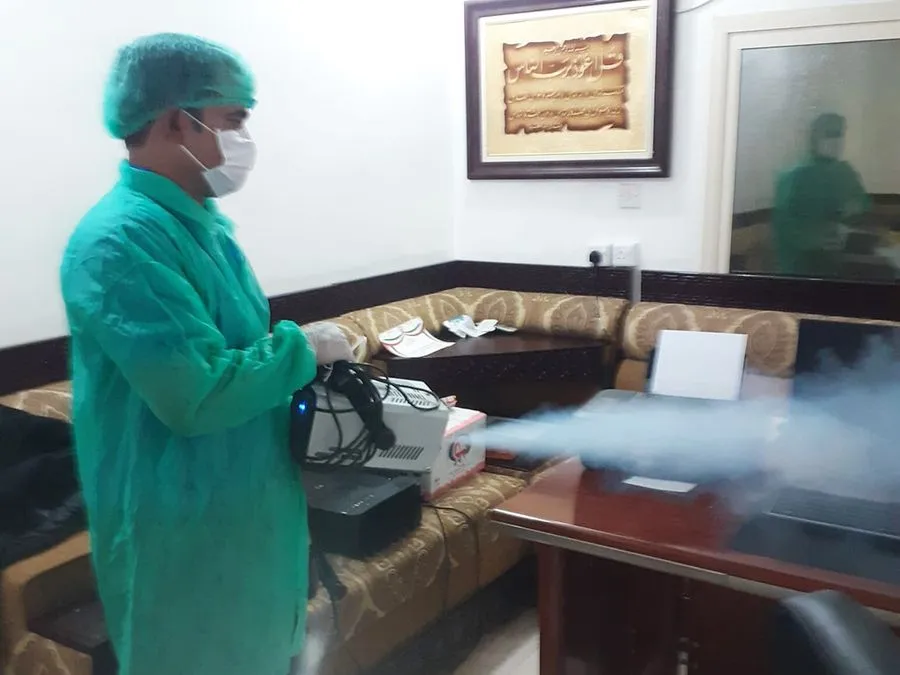 A men disinfecting room from spreading infection using a fog gun